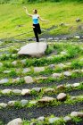 Mulher em ioga posar em pedra no labirinto — Fotografia de Stock