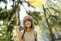Woman carrying balloons in park — Stock Photo