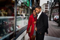 Couple window shopping on city street — Stock Photo