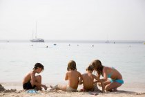 Groupe d'enfants jouant sur la plage — Photo de stock