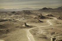 Vista de ángulo alto de Trona Pinnacles y sinuoso camino del desierto, Trona, California, EE.UU. - foto de stock