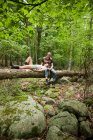 Casal relaxando juntos no log na floresta — Fotografia de Stock