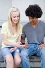 Teenage couple with cellphone — Stock Photo