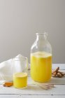 Bodegón de limonada de limoncillo tumérico en vaso y botella - foto de stock