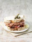Carne en conserva, encurtidos y sándwich de rábano en rodajas de pan blanco con pepinillos y cebollas en escabeche - foto de stock