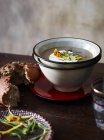 Table avec bol de soupe aux champignons et estragon et pain brun — Photo de stock