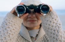 Mujer mayor usando prismáticos - foto de stock