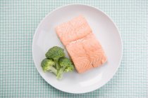 Salmon and broccoli on plate, top view — Stock Photo