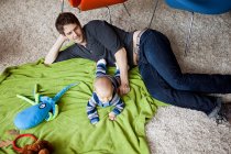 Pai brincando com bebê filho na sala de estar — Fotografia de Stock