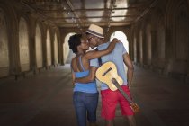 Vue arrière d'un jeune couple avec mandoline à Bethesda Terrace arcade, Central Park, New York, USA — Photo de stock