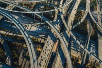 Vista aérea de viadutos curvos e rodovias à luz do sol — Fotografia de Stock