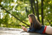 Женщина, использующая мобильный телефон в парке — стоковое фото