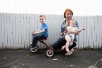 Mother playing in yard with two children — Stock Photo