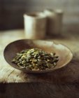 Organic pumpkin seeds in wooden bowl — Stock Photo
