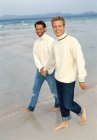 Männer gehen am Strand spazieren — Stockfoto