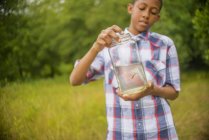 Teenage boy with fish in jar — Stock Photo