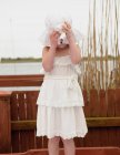 Girl covering face with white sunhat — Stock Photo