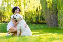 Mulher com cão na grama — Fotografia de Stock