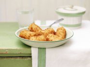 Картофельные крокеты в винтажном блюде с ложкой — стоковое фото