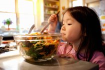 Дівчина міксує салат у салатній мисці — стокове фото