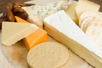 Close-up view of board with various cheese and crackers — Stock Photo