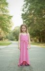Smiling girl standing on rural road — Stock Photo