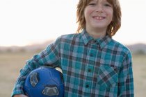 Портрет хлопчика, що тримає футбольний м'яч — стокове фото