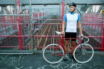 Cycliste debout sur le pont avec vélo, Brooklyn, Etats-Unis — Photo de stock
