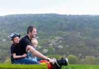 Mature man riding motorbike with sons — Stock Photo