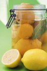 Preserved lemons in jar and fresh ones — Stock Photo