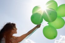 Woman carrying bunch of balloons — Stock Photo