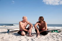 Due surfisti che parlano in spiaggia — Foto stock