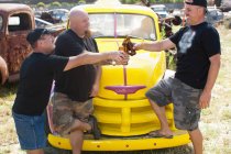 Чоловіки п'ють пиво на барвистій машині — стокове фото