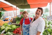 Deux femmes commerçantes sur étal de légumes — Photo de stock