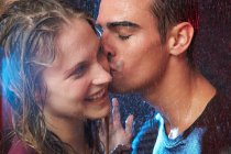 Young couple kissing in the rain — Stock Photo