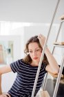 Businesswoman leaning at ladder in the room — Stock Photo