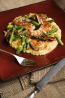Shrimps and asparagus served on bed of polenta — Stock Photo