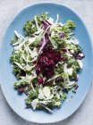 Верхний вид листьев салата на блюдо синего цвета — стоковое фото