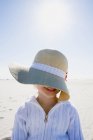 Дівчина в солом'яному капелюсі позує на пляжі — стокове фото