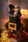 Jovem casal abraçando na cadeira no Natal — Fotografia de Stock