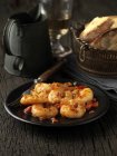 Still life starter of cooked king prawns on black plate — Stock Photo
