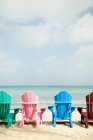 Espreguiçadeiras coloridas na praia, vista traseira — Fotografia de Stock