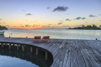Two sun loungers on waterfront boardwalk at sunset, St. Georges Caye, Belize, Central America — Stock Photo
