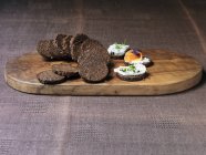 Mini-Pumpernickel mit Käse und Lachs auf Holzhackbrett — Stockfoto