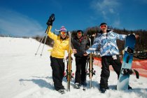 Tres amigos usando ropa de esquí con esquís - foto de stock