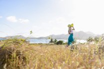 Femme debout dans un champ herbeux — Photo de stock