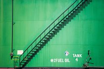 Tanque de óleo e parede pintada verde — Fotografia de Stock