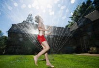 Junge läuft durch Sprinkleranlage — Stockfoto