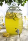 Стеклянная бочка с колодкой, содержащей свежий лимонадный напиток — стоковое фото