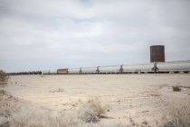 Зменшення подання вантажного поїзда в пустелі під хмарного неба — стокове фото